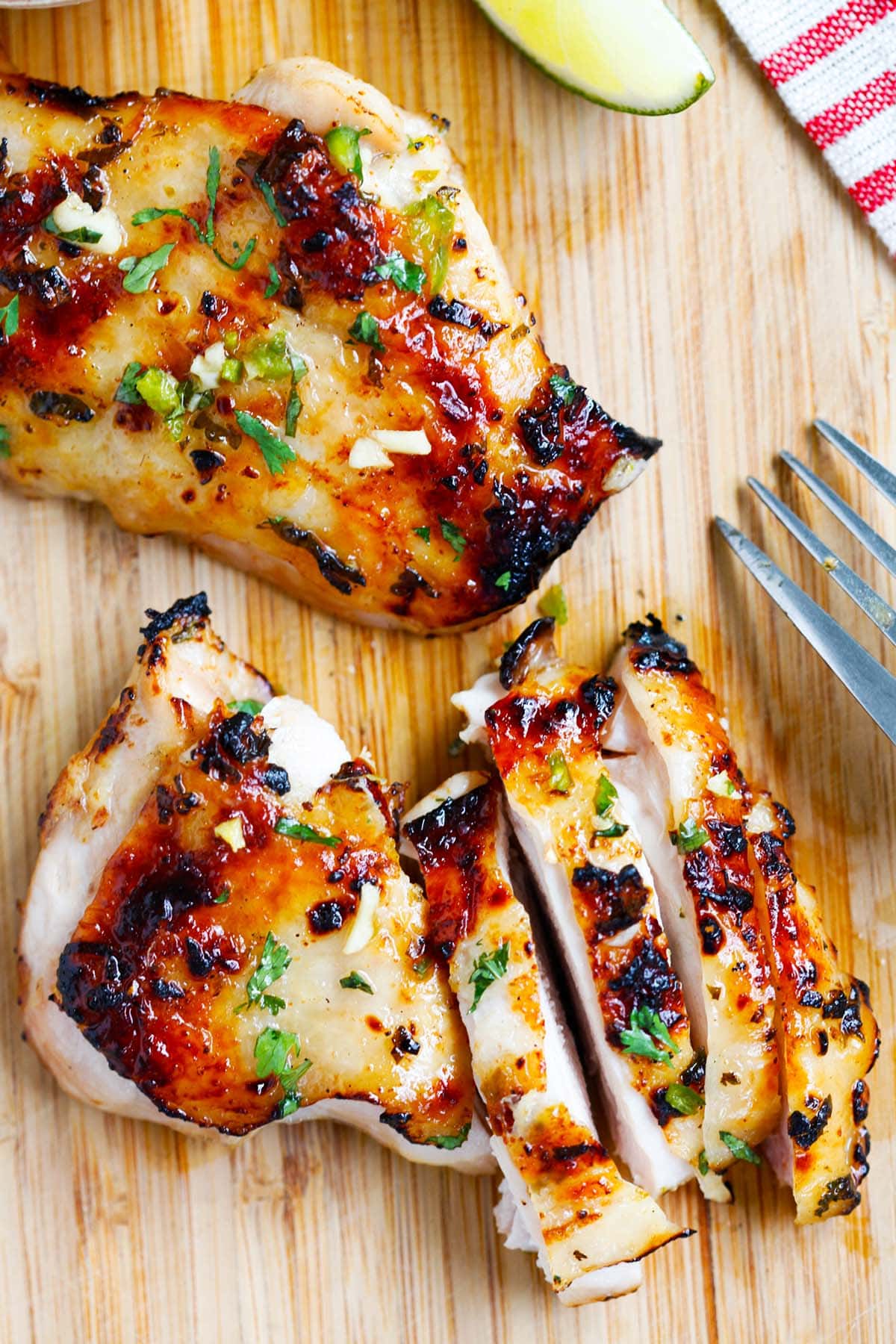 Delicious chili lime grilled chicken on a wooden chopping board.