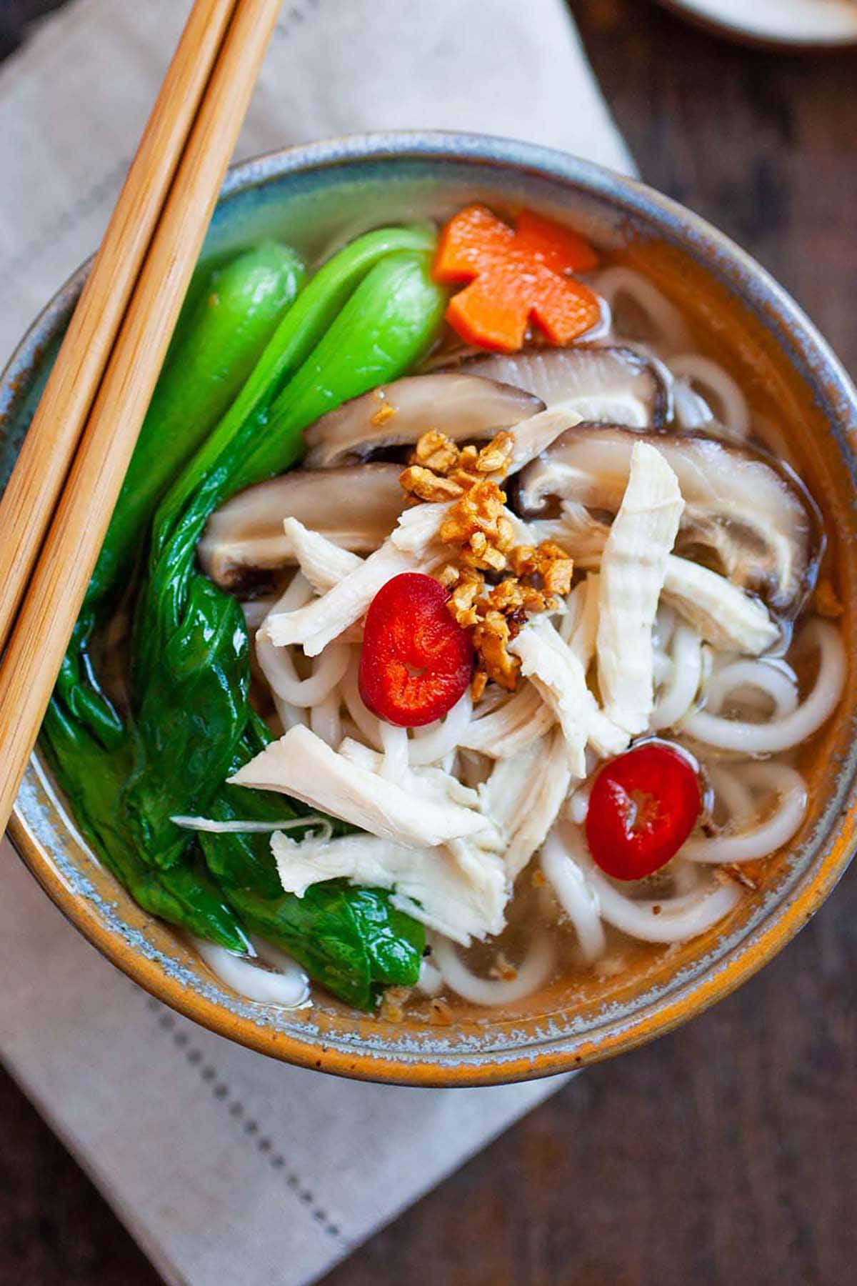 Asian noodle soup with chicken, bok choy vegetables and noodles in a bowl.