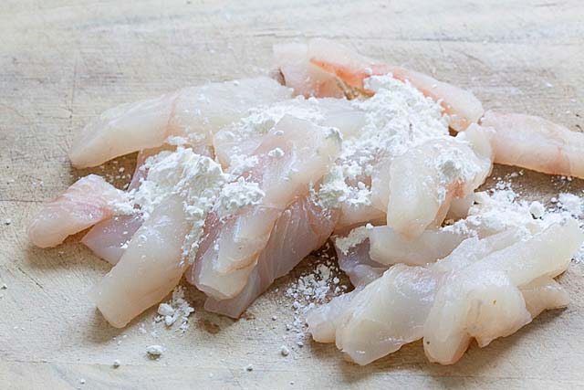 Pacific halibut cut into small pieces on a cutting board, ready to cook. 
