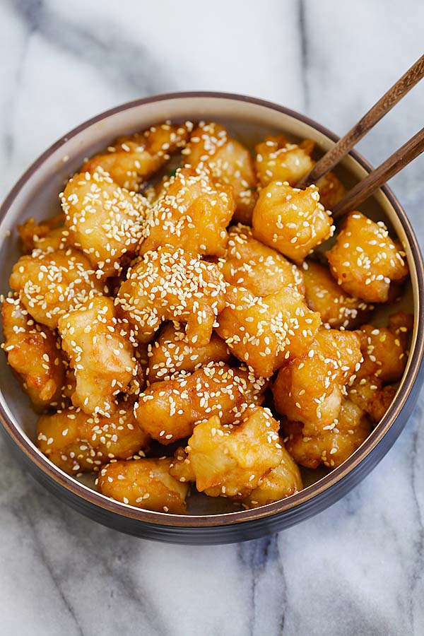 Fried honey sesame chicken covered in sauce and sesame seeds.