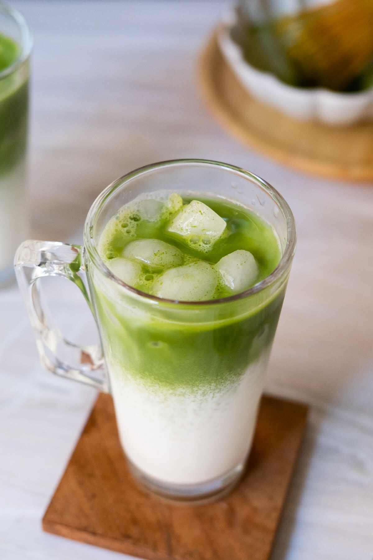 One glass of green tea latte with ice cubes.
