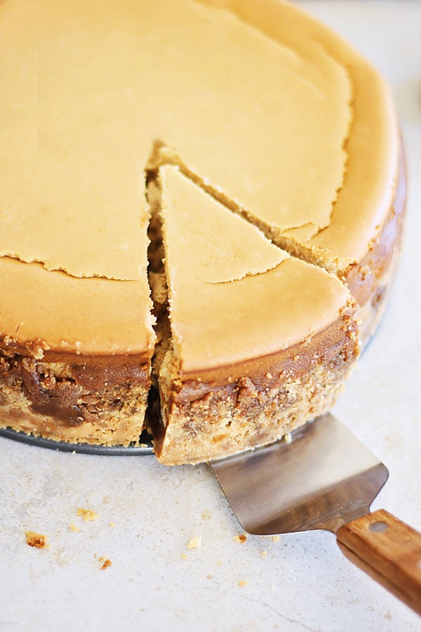 Rich and creamy cheesecake loaded with pecan and syrup being sliced and picked by cake shovel.
