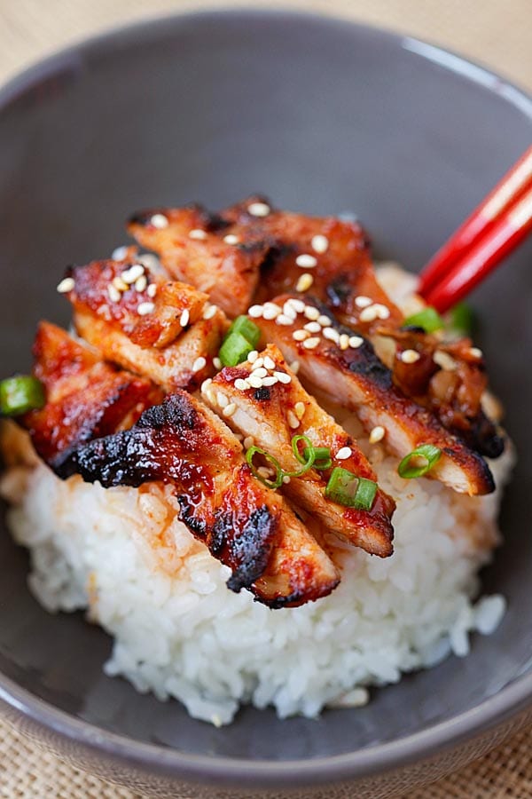 Close up of Korean chicken with spicy gochujang sauce, with sesame seeds.